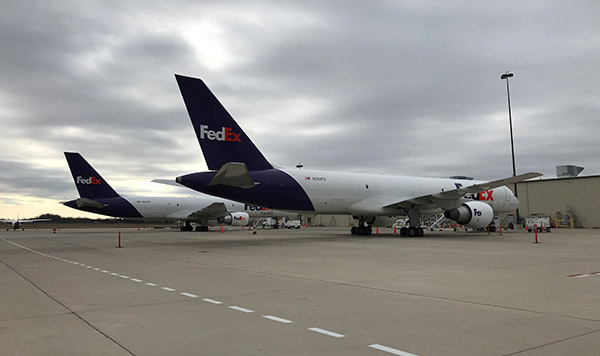 Two FedeX planes sitting on the tarmac at Flint Bishop airport.