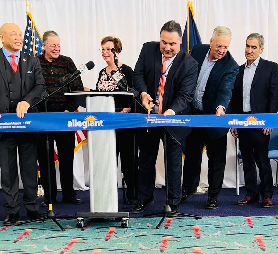 Six board members cutting an Allegiant airline ribbon. Pictured from left to right: Loyst Fletcher, Jr., Kevin Keane, Nino Sapone, A.A.E., Winfield Cooper, III, and Mark Yonan