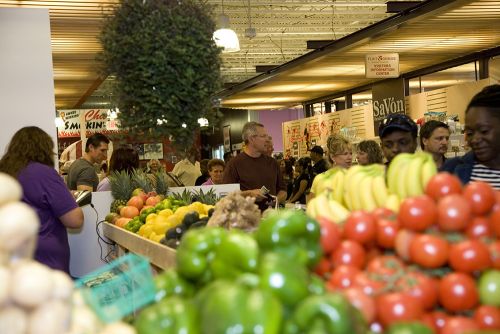 The image shows vegetable stands at the Flint Farmers Market.