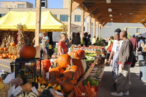 The image is of pumpkins and vegetables at the Flint farmer market. 